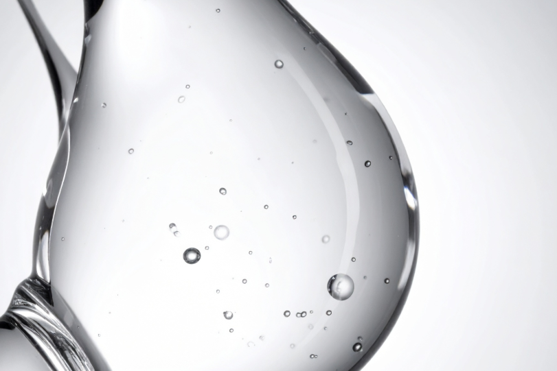 Close-up of clear liquid droplets on a white background, representing the Hyaluronic Acid added to the Move Blend Supplement